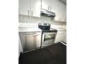 Close-up of the stainless steel oven and dishwasher, complemented by a modern tile backsplash at 13100 Serpentine Dr, Hudson, FL 34667