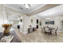 Open-concept dining area with tile floors, a modern light fixture, and neutral decor at 13903 Sage Thrasher Ln, Riverview, FL 33579