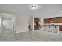 Expansive living area featuring tile flooring, neutral walls, stairway access, and seamless transition to a modern kitchen at 16016 Persimmon Grove Dr, Lithia, FL 33547