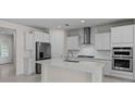 Bright kitchen featuring stainless appliances, white cabinets, subway tile, and an island at 2280 Long Spur, Odessa, FL 33556
