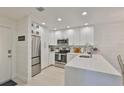 Bright kitchen with white cabinets, stainless steel appliances, and a marble backsplash at 230 Medallion Blvd # F, Madeira Beach, FL 33708