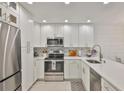 Bright kitchen with white cabinets, stainless steel appliances, and a marble backsplash at 230 Medallion Blvd # F, Madeira Beach, FL 33708