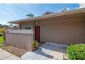 Exterior view of a well-maintained home with a red front door, landscaping, and clear signage at 2444 Laurelwood Dr # A, Clearwater, FL 33763