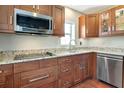 Well-equipped kitchen featuring wood cabinets, granite countertops, and stainless steel appliances at 2444 Laurelwood Dr # A, Clearwater, FL 33763