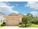Garage door with lamps, manicured lawn and blue skies at 30764 Lindentree Dr, Wesley Chapel, FL 33543
