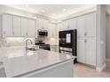 Bright kitchen with white cabinets, stainless steel appliances, and quartz countertops at 30764 Lindentree Dr, Wesley Chapel, FL 33543