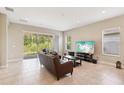 Open living room with tile flooring, sliding glass doors, and comfortable seating arrangement at 30764 Lindentree Dr, Wesley Chapel, FL 33543