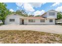 Quaint two-story home featuring a spacious front yard and a long driveway with car port at 311 Jeanal Pl, Tampa, FL 33612