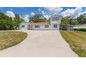 Quaint two-story home featuring a spacious front yard and a long driveway with car port at 311 Jeanal Pl, Tampa, FL 33612