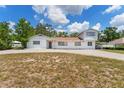 Quaint two-story home featuring a spacious front yard and a long driveway with car port at 311 Jeanal Pl, Tampa, FL 33612