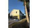 Two-story home with a screened garage, stairway, and large trees at 3338 Fernleaf Dr, Hernando Beach, FL 34607