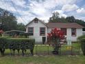 Lovely home featuring white siding with contrasting red trim, complemented by manicured greenery at 3405 E Diana St, Tampa, FL 33610