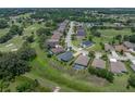Aerial view features the back of a single Gathering home overlooking a golf course and lush green community at 34652 Heavenly Ln, Dade City, FL 33525