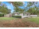 Lovely single-story home with gray exterior, fenced yard, and mature trees offering shade and privacy at 3547 55Th N St, St Petersburg, FL 33710
