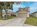A cozy two-story home featuring a two-car garage and a well-manicured lawn at 4228 Savage Station Cir, New Port Richey, FL 34653