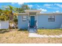 Up close view of exterior with blue painted facade, small porch and front door at 513 88Th N Ave, St Petersburg, FL 33702