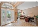 Bright entryway leads to a living area with laminate flooring, an office, and a decorative glass front door at 5704 Eaglemount Cir, Lithia, FL 33547