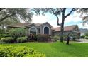 Charming one-story home featuring manicured lawn and mature trees in front yard at 5704 Eaglemount Cir, Lithia, FL 33547