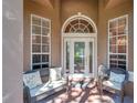 Inviting front porch with seating area featuring a decorative glass front door at 5704 Eaglemount Cir, Lithia, FL 33547