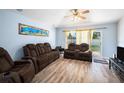 Relaxing living room with modern flooring, comfortable seating, and sliding glass doors at 5860 War Admiral Dr, Wesley Chapel, FL 33544