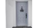 Condo front door with number 605, featuring decorative welcome sign, hardware, and tiled design at 6265 Sun Blvd # 605, St Petersburg, FL 33715