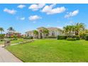 Expansive one-story home with lush landscaping and bright blue skies creates a serene tropical oasis at 703 Monte Cristo Blvd, Tierra Verde, FL 33715