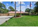 Ranch home with large front yard, mature landscaping, and American flag on a sunny day at 7507 Beasley Rd, Tampa, FL 33615