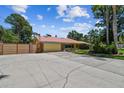 Ranch home with large driveway, mature trees, and fenced yard on a sunny day at 7507 Beasley Rd, Tampa, FL 33615