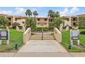 Inviting building entrance with well-manicured landscaping, a central walkway, and signage for the units at 7520 Sunshine Skyway S Ln # 109, St Petersburg, FL 33711