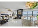 Elegant living room with tile flooring, a fireplace, water views, and an adjacent dining area at 7520 Sunshine Skyway S Ln # 109, St Petersburg, FL 33711