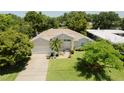 Beautiful home showcasing lush landscaping, a well-maintained lawn, and a welcoming front entrance at 3010 Grand View Ave, Clearwater, FL 33759