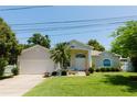 Charming home featuring a well-manicured lawn, beautiful landscaping, and a welcoming double-door entrance at 3010 Grand View Ave, Clearwater, FL 33759