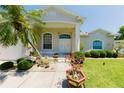 Inviting home featuring a manicured lawn, lush landscaping, and a decorative double-door entrance at 3010 Grand View Ave, Clearwater, FL 33759