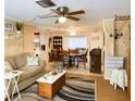 Open-concept living and dining area with neutral tones, ceiling fan, and stylish furnishings at 10031 Cherry Creek Ln, Port Richey, FL 34668
