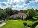 Expansive home with red tile roof, pristine lawn, and mature landscaping at 10504 Echo Lake Dr, Odessa, FL 33556