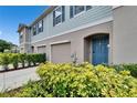 Close up of a charming townhome featuring a front-entry garage, and a well-manicured lawn at 10907 Golden Acorn Ave, Tampa, FL 33610