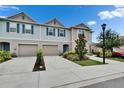 Inviting townhome featuring a front-entry garage, landscaped yard, and a well-maintained lawn at 10907 Golden Acorn Ave, Tampa, FL 33610