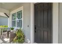 Welcoming front entrance with a black front door, outdoor seating, and neat landscaping at 11510 Quiet Forest Dr, Tampa, FL 33635
