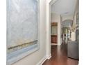 Bright hallway with dark wood floors, decorative art and arched doorways at 11510 Quiet Forest Dr, Tampa, FL 33635