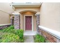 Inviting entryway with stone pillars, detailed trim, and lush landscaping at 11839 Castine St, New Port Richey, FL 34654