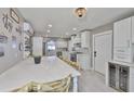 Bright, modern kitchen with white cabinets, stainless steel appliances, large center island with chairs, and a wine fridge at 12468 Empire Dr, Seminole, FL 33772