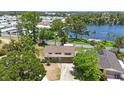 Aerial view of a home near a lake, surrounded by lush greenery and neighboring houses in a serene setting at 12803 126Th Ter, Largo, FL 33774