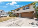 Two-story home with stone accents and a brown two-car garage door, complemented by a well-kept driveway at 12803 126Th Ter, Largo, FL 33774