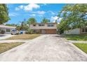 Charming two-story home featuring a stone-accented base and a spacious driveway under a clear blue sky at 12803 126Th Ter, Largo, FL 33774