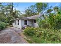 Cozy home with lush green landscaping and a weathered driveway at 15012 N 301 Hwy, Thonotosassa, FL 33592