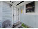 Inviting front porch with a light blue door and a wicker chair at 15012 N 301 Hwy, Thonotosassa, FL 33592