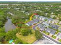 Aerial view of the property showcasing its location near a pond and other homes in a lush, green neighborhood at 152 Glenn Moor Cir, Dunedin, FL 34698