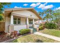 Welcoming single-story home featuring a cozy front porch with elegant columns and lush landscaping at 1530 21St N Ave, St Petersburg, FL 33704