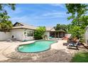 Inviting backyard with a freeform pool, patio furniture, and a screened-in porch, perfect for outdoor relaxation at 15801 Cottontail Pl, Tampa, FL 33624