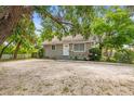 Charming single-story home featuring a simple front facade with grey paint, complemented by the surrounding lush greenery at 2038 16Th S St, St Petersburg, FL 33705